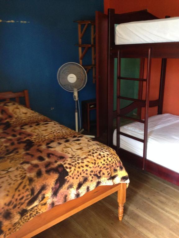 a room with two bunk beds and a fan at Hostal Surf Olón in Olón