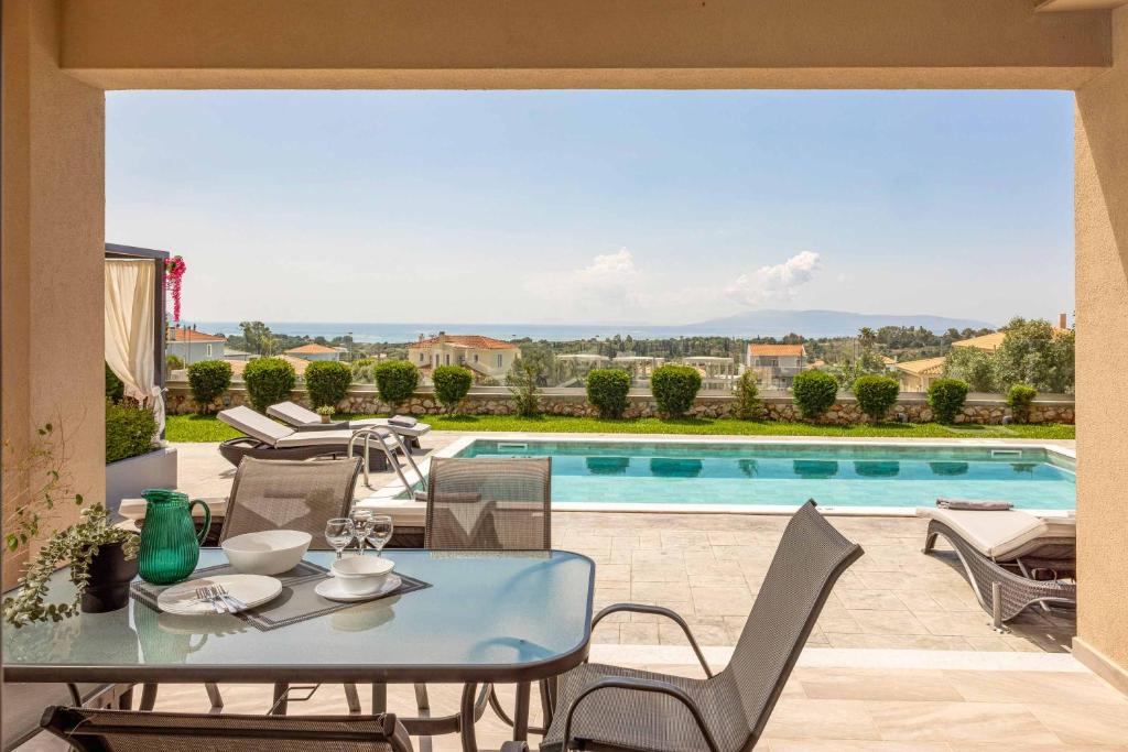 a patio with a table and chairs and a swimming pool at Casa Bella in Karavádhos