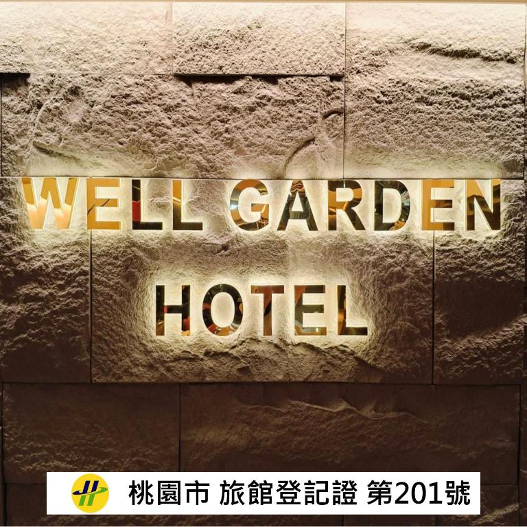 a sign that reads well garden hotel on a stone wall at Well Garden Hotel in Taoyuan