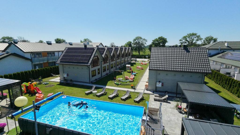 an overhead view of a swimming pool with people in it at Domki Gala- blisko plaży, basen z podgrzewaną wodą , sauna , parking in Grzybowo