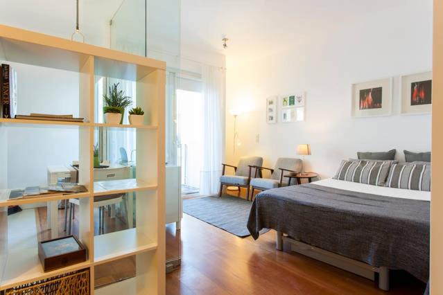 ein Schlafzimmer mit einem Bett und ein Wohnzimmer in der Unterkunft Santa Catarina Apartment - No centro da cidade com garagem, perto do TimeOut Market in Lissabon