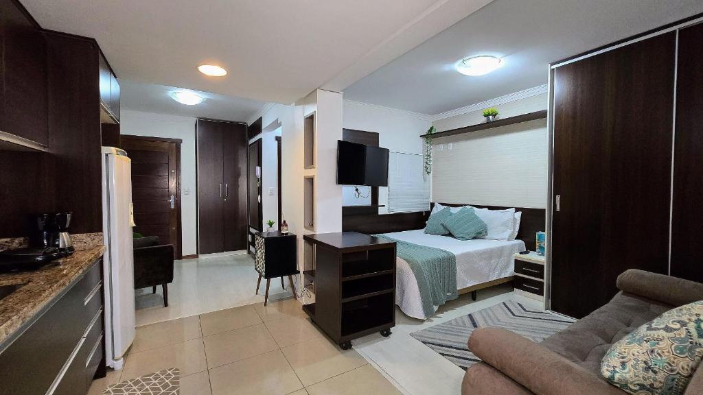 a hotel room with a bed and a couch at Baviera Studio Canela in Canela