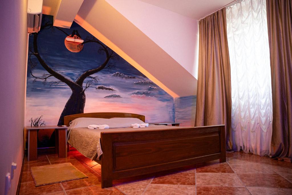 a bedroom with a bed with a painting on the wall at Rooms Asceric in Stari Banovci