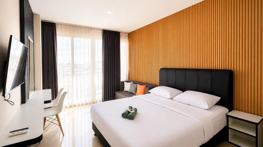 a hotel room with a bed and a tv at SleepRest @ NTC in Nagoya