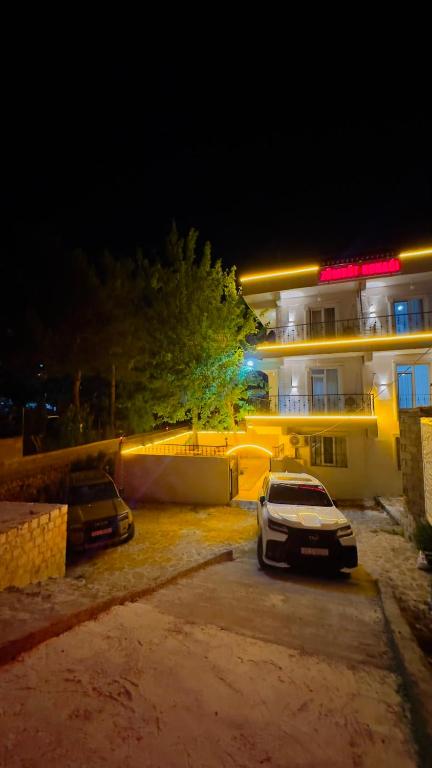 two cars parked in front of a building at night at ZÜMRÜT KONAĞı in Mardin