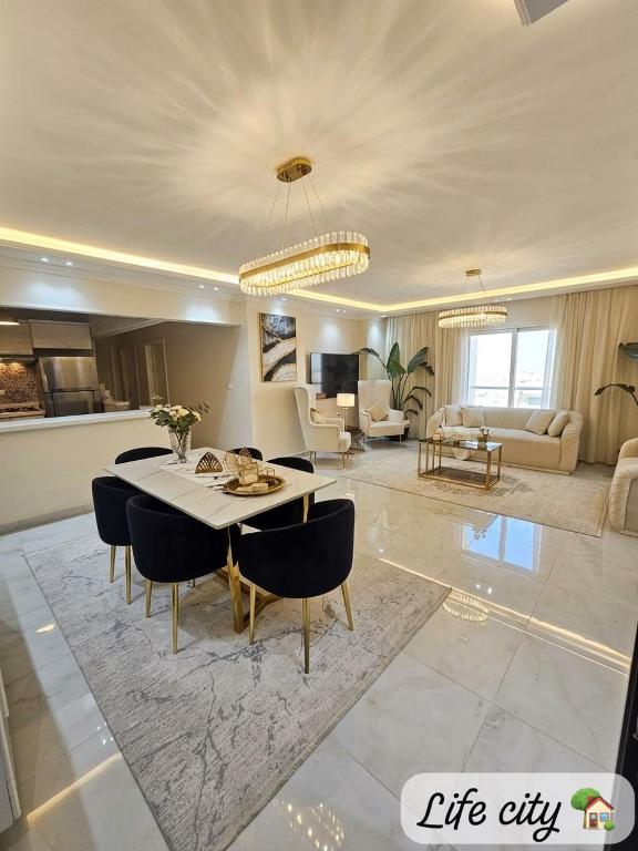 a large living room with a table and chairs at Life city home in 6th Of October
