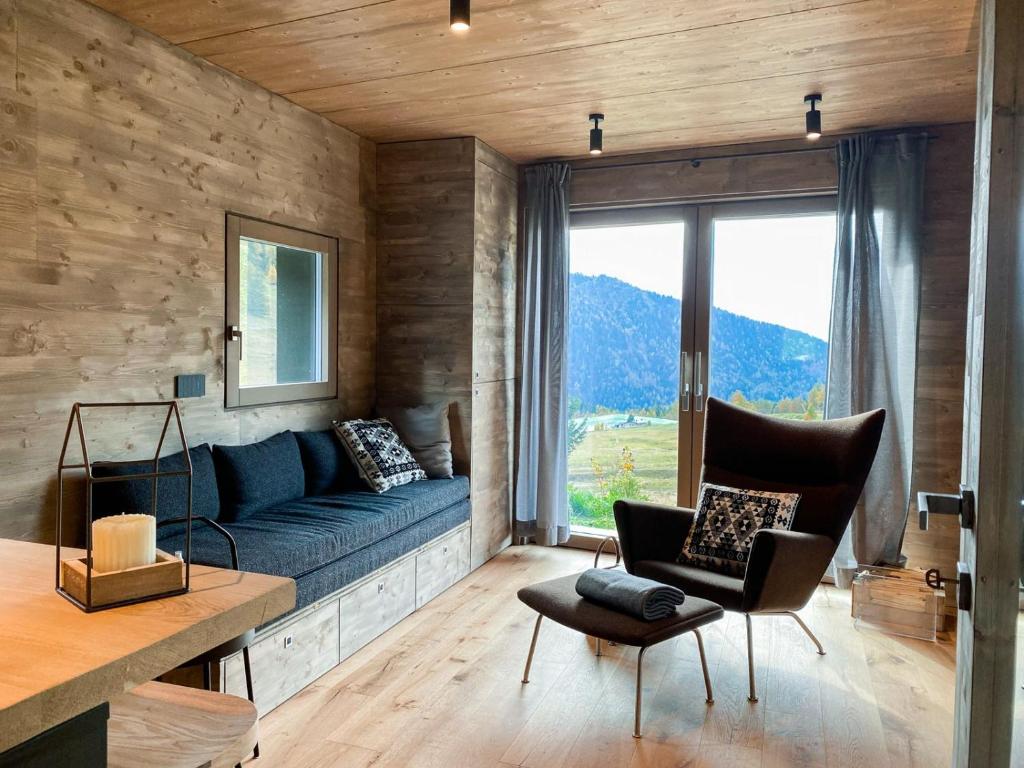 a living room with a blue couch and a window at Chalet Baita Aria - AffittiPontediLegno in Ponte di Legno