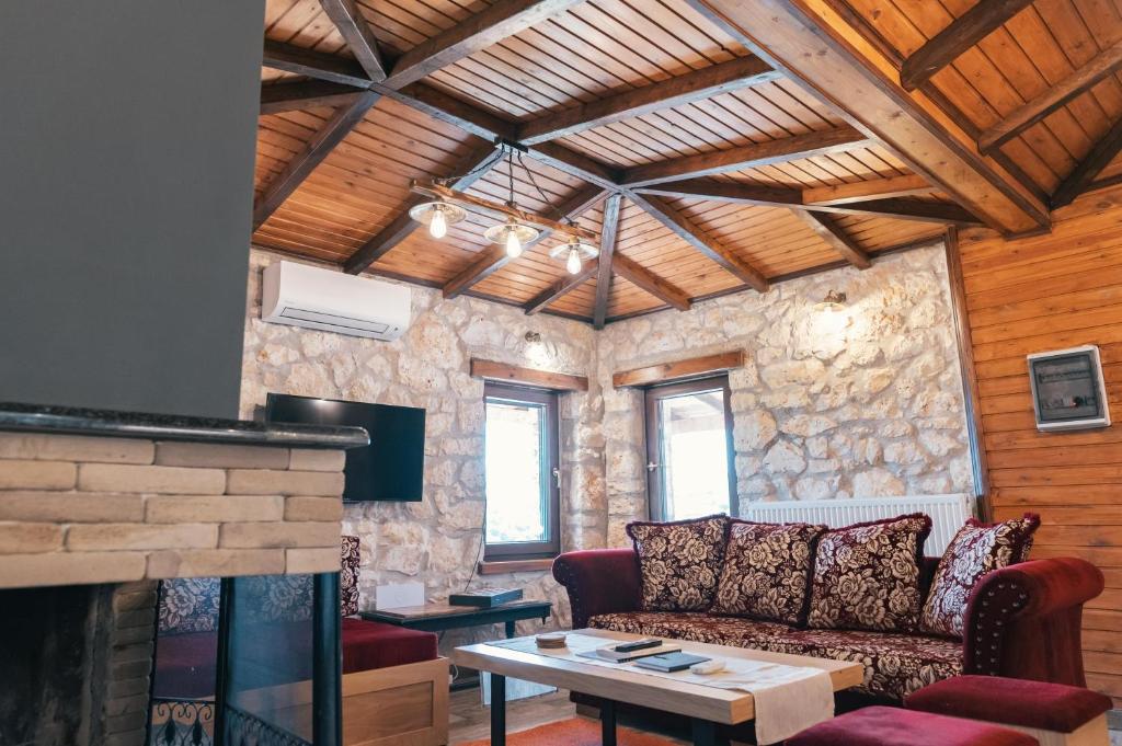 a living room with a couch and a fireplace at Κτήμα Βασίληγιάννη in Kouklésion