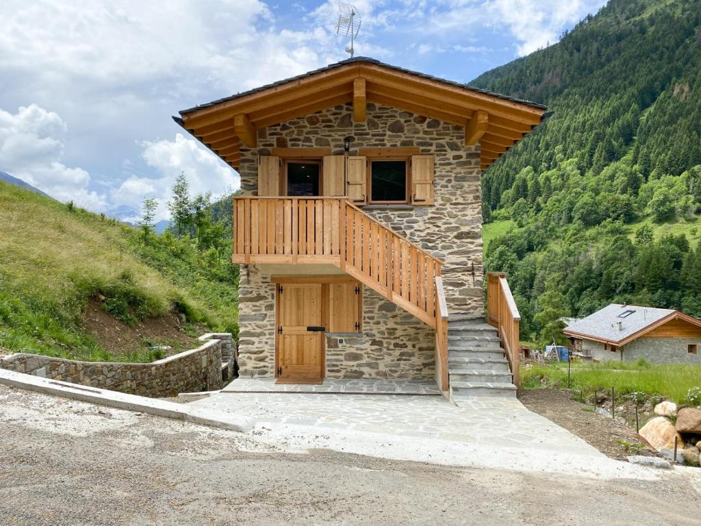 a small building with a balcony on the side of a mountain at Chalet la Mia Baita - AffittiPontediLegno in Pezzo