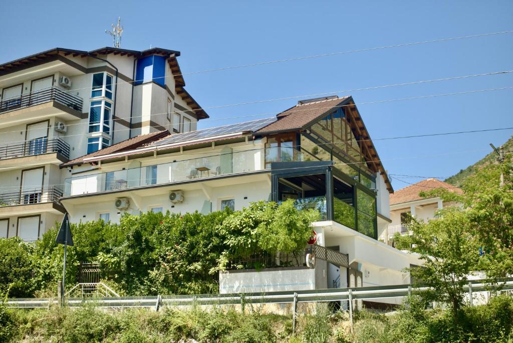 a large white building with blue windows at Villa Osmani in Shkodër