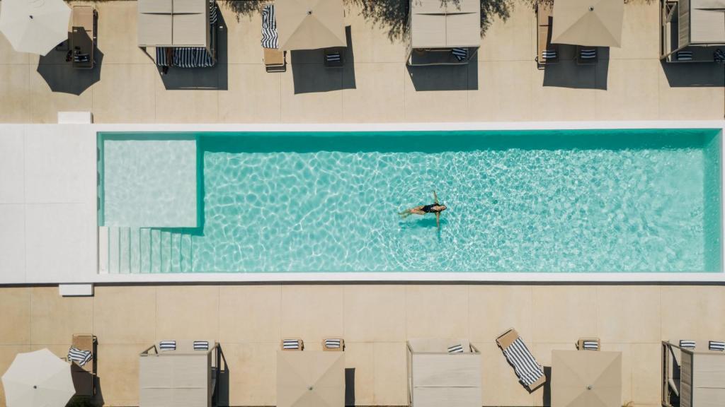 a person swimming in a swimming pool at Gandum Village - Conscious Boutique Hotel in Montemor-o-Novo