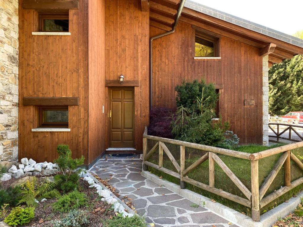 a house with a wooden facade with a wooden door at Mansarda Santa Chiara - AffittiPontediLegno in Temù