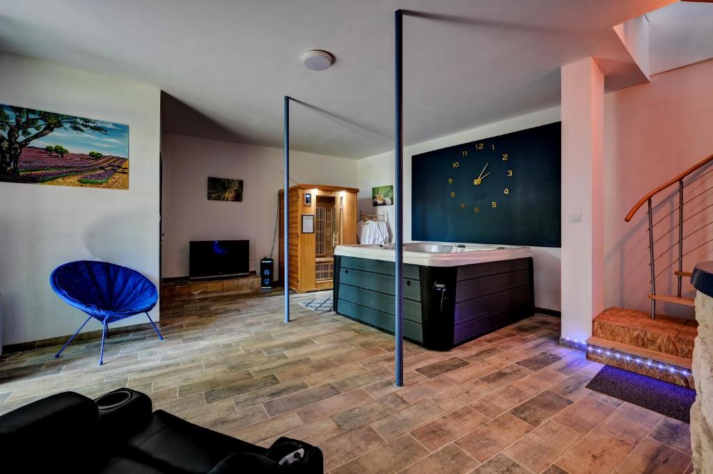 a living room with a blue chair and a sink at lemasrocamour in Roquemaure