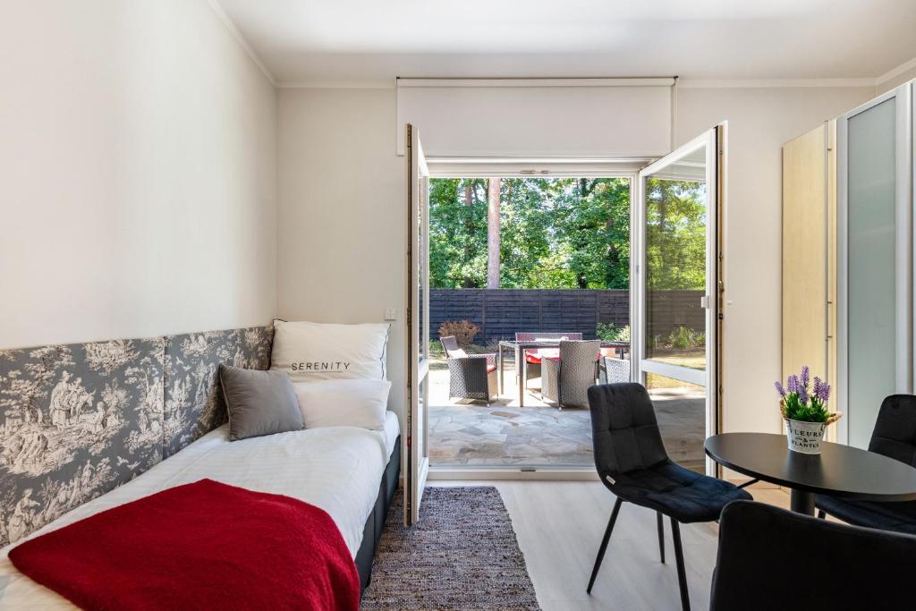 a bedroom with a bed and a table and chairs at Lakeside Retreat Apartment in Bestensee