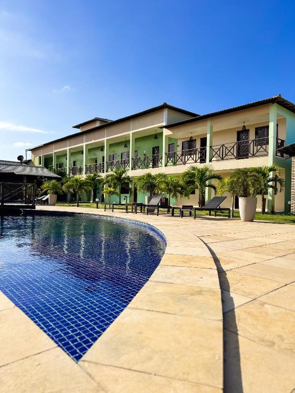 a building with a swimming pool in front of a building at Pousada Bellissima Italia in Luis Correia