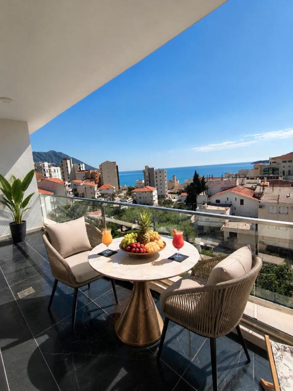 a balcony with a table with a bowl of fruit on it at Dreams house elia in Budva
