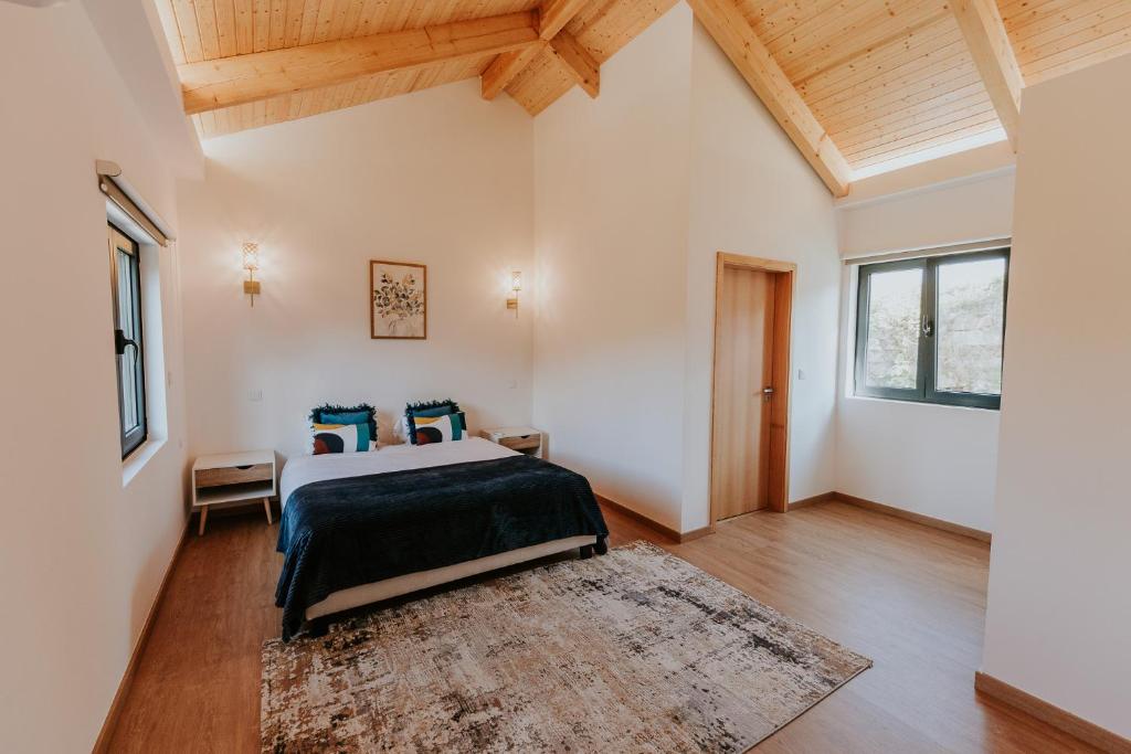 a bedroom with a bed with blue pillows at Quinta do Codeçal in Vila Real
