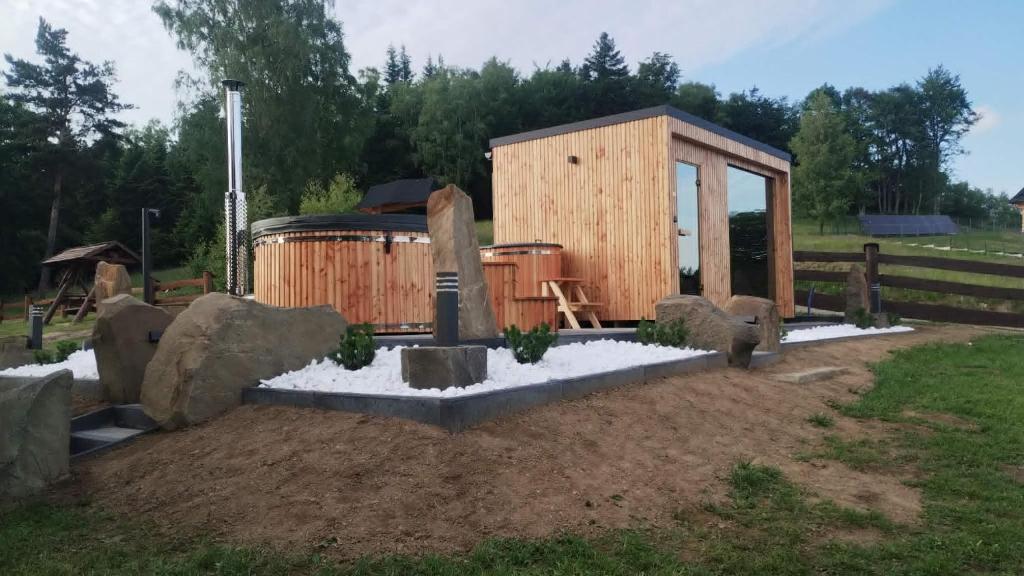 a small wooden cabin with a barrel in a yard at Domki Pod Biegunem, Strefa Relaksu, Bajkowy Świat Smerfów in Żywiec