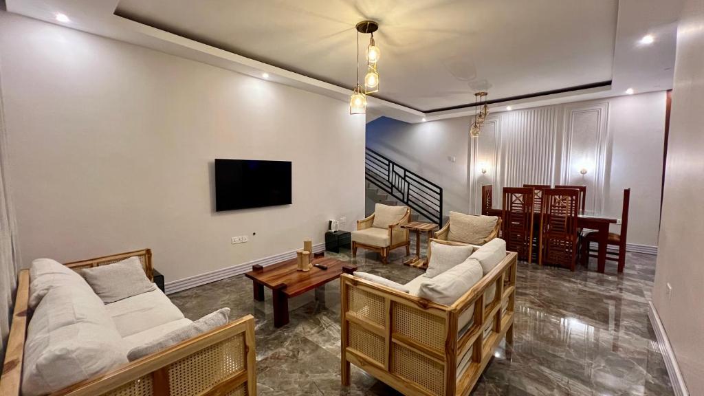 a living room with two couches and a tv at The Yoyo's Stay in Arusha
