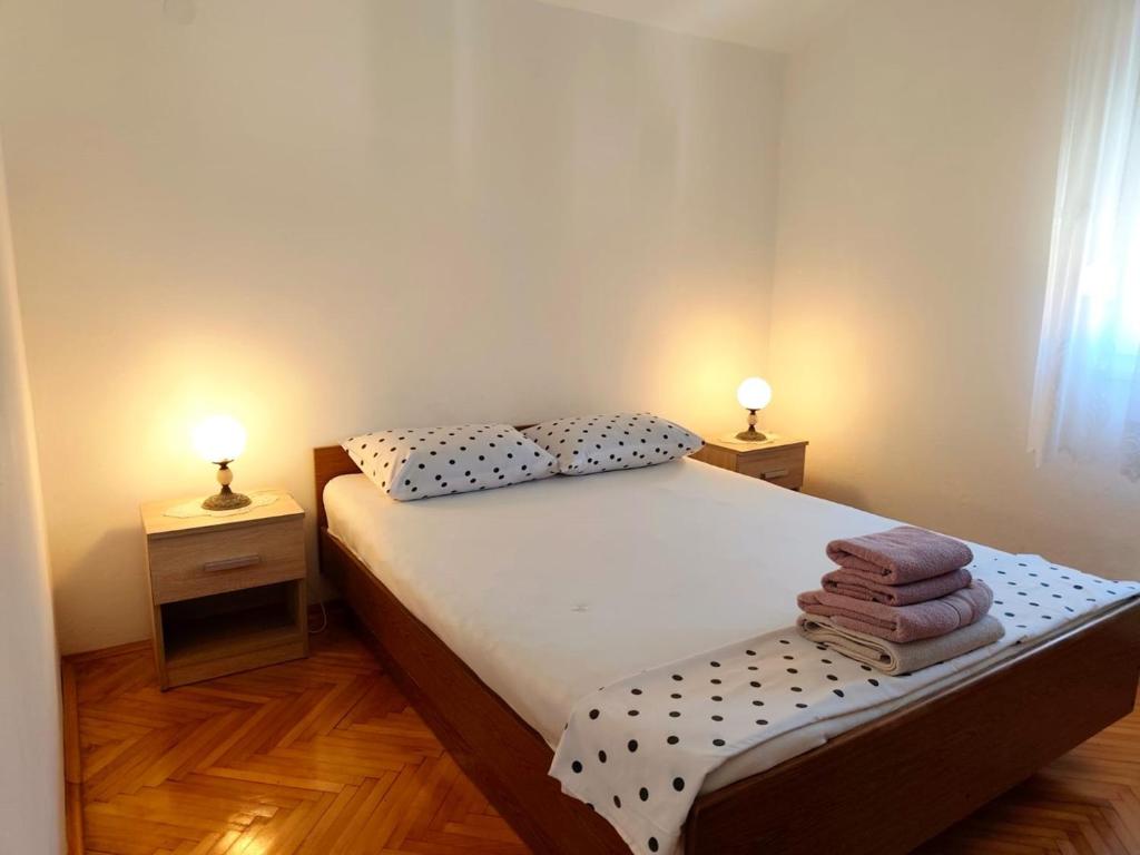 a small bedroom with a bed with two lamps on both sides at Apartment Josip in Primošten