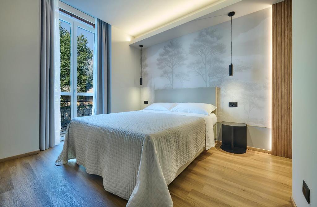 a bedroom with a large bed and a large window at Monolocale 1 - via Sassi, Lecco in Lecco