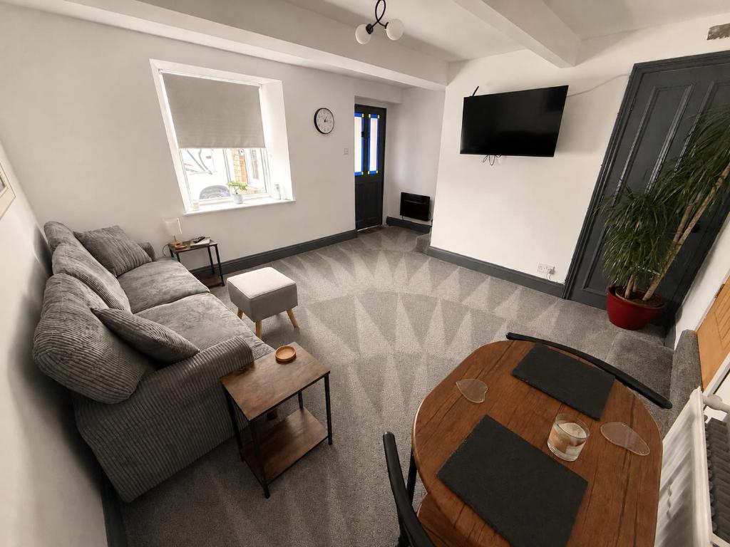 a living room with a couch and a table at Self contained property in Cartworth