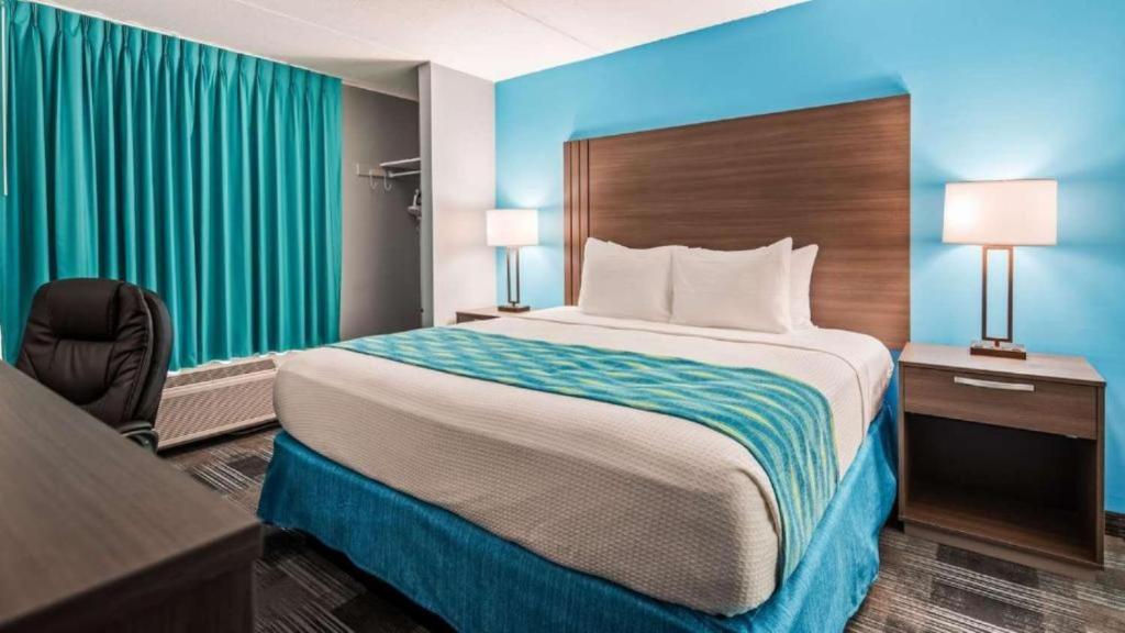 a hotel room with a large bed and a desk at Quality Inn Jacksonville South in Jacksonville