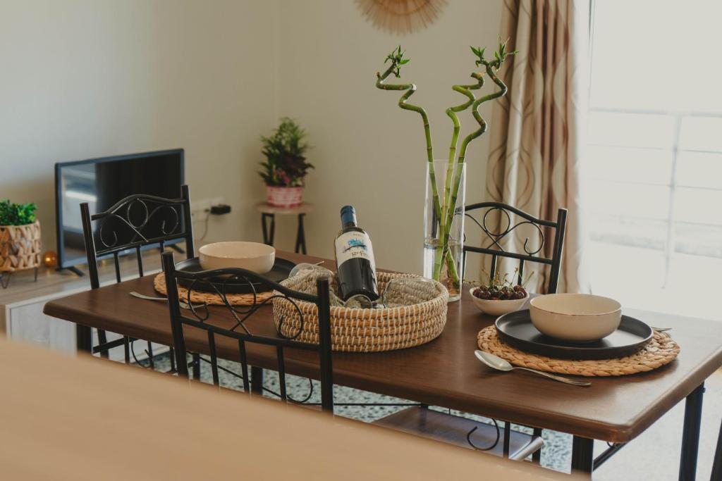 a dining room table with a bottle of wine on it at The Beach House in Karistos