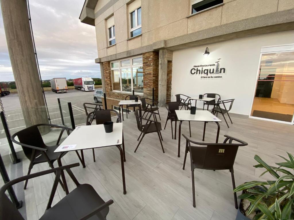 a group of tables and chairs in front of a building at Hotel Chiquín in Tapia de Casariego