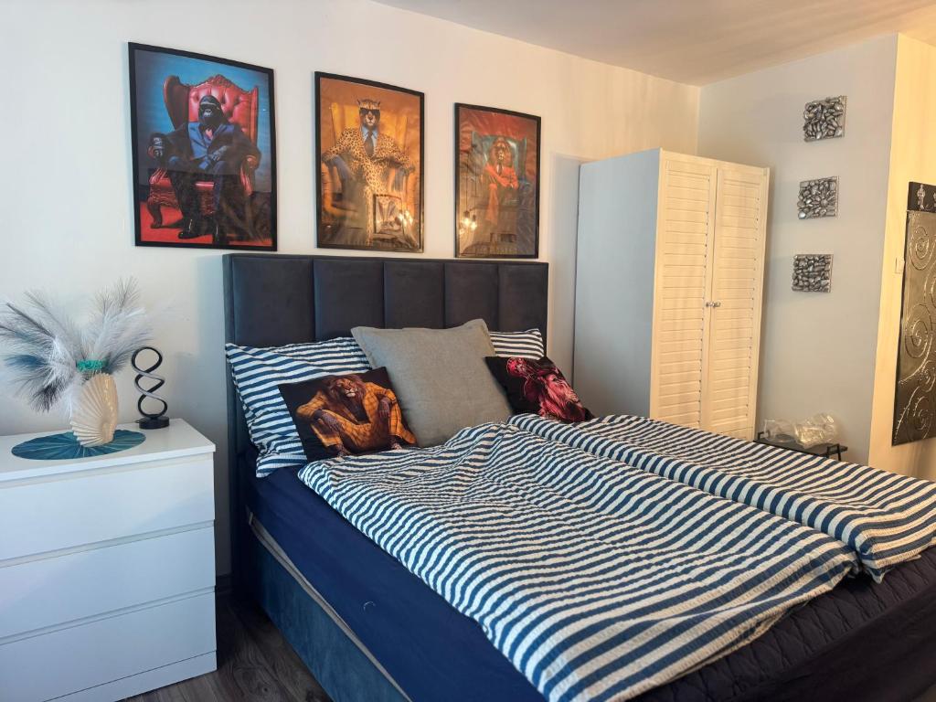 a bedroom with a bed and some pictures on the wall at Paloma Blanca 2 in Gárdony