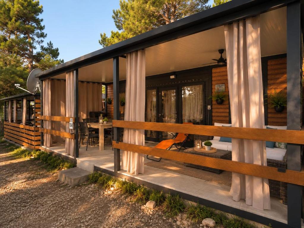 a home with a large porch with a bench at Mobilehome Lana in Privlaka