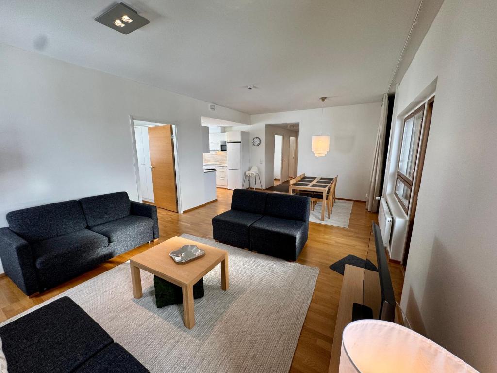 a living room with two black couches and a table at Ylläs Chalets 7305 in Ylläs