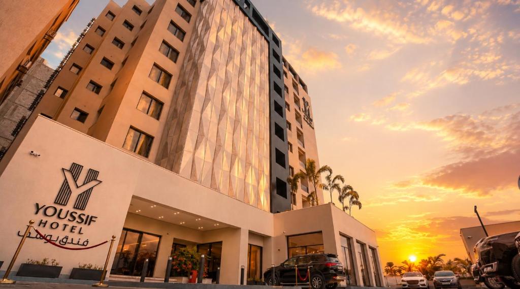a hotel building with a sunset in the background at Youssif Hotel in Dakākīn Ḩamīd