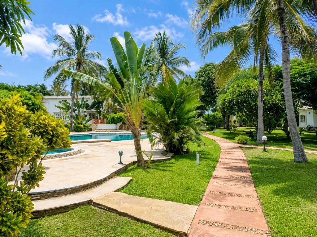a resort with a swimming pool and palm trees at Tropical Court 2 BedroomDiani Beach villa in Kwale