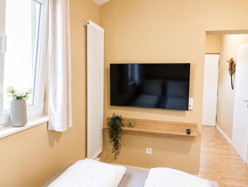 a living room with a flat screen tv on a wall at MeinZuhause Apartmente NG in Bad Pyrmont