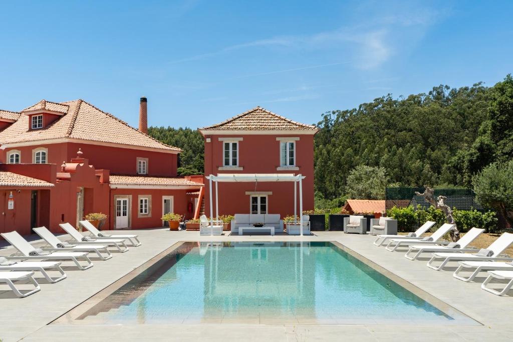 a swimming pool with lounge chairs and a house at Paço do Bispo Boutique House in Sintra