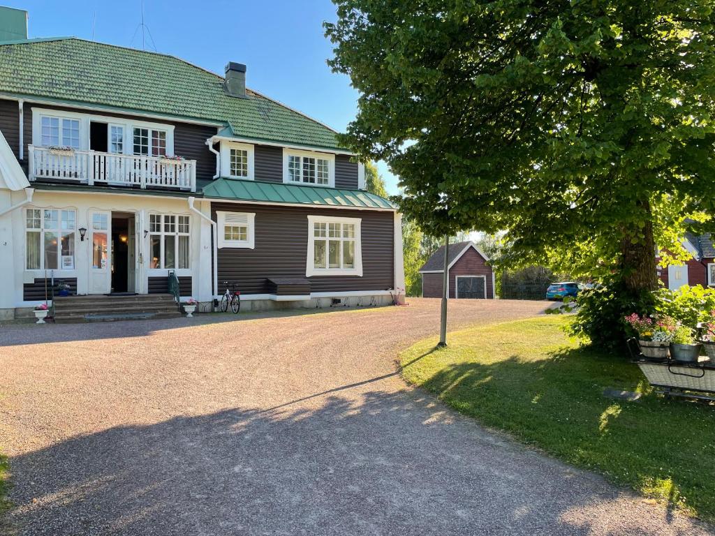 a large house with a tree and a driveway at Trunnagården in Orsa
