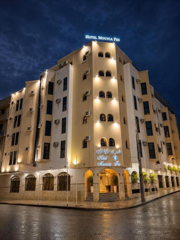 a large white building with a sign on it at Hotel Mounia in Fez
