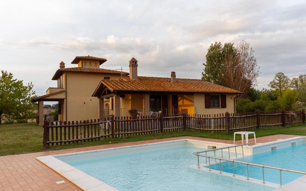 a house with a swimming pool in front of a house at Poggio Mille in Castiglione del Lago