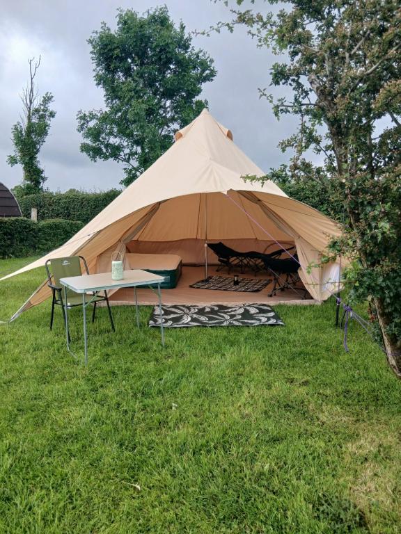 a large tent with a table in the grass at Hal`s at Killynick in Killyhevlin