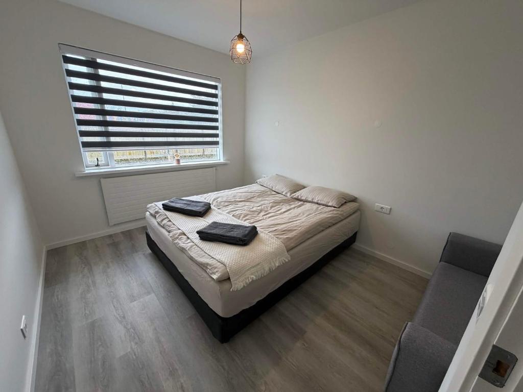 a small bedroom with a bed with a window at Vesturgata 8 KEF in Keflavík