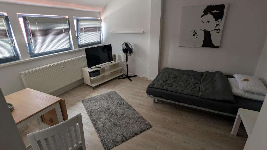 a living room with a bed and a tv at Gemütliche 1-Zimmer-Wohnung im Hildesheimer Wald in Diekholzen
