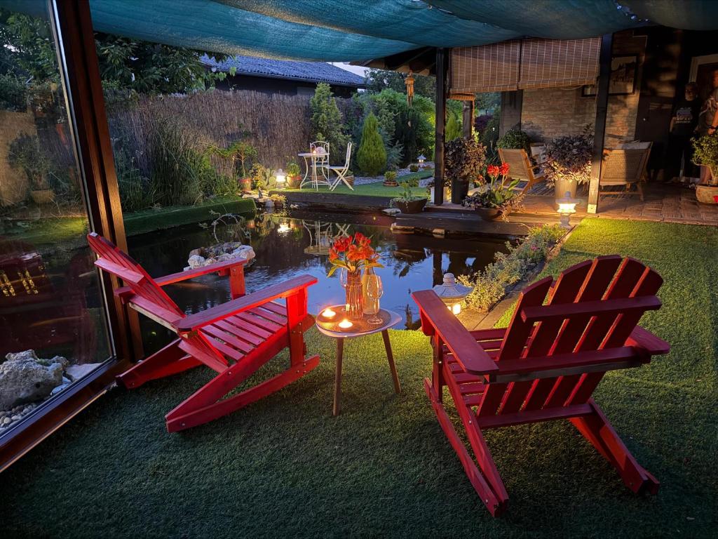 two red chairs and a table in a yard at Kuća za odmor Leon in Vinkovci