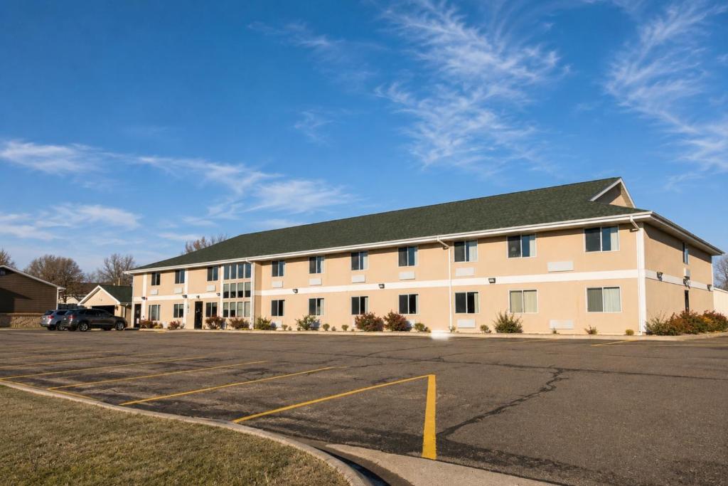 a large white building with a parking lot at Bilmar Inn & Suites Dell Rapids Near Sioux Falls in Dell Rapids