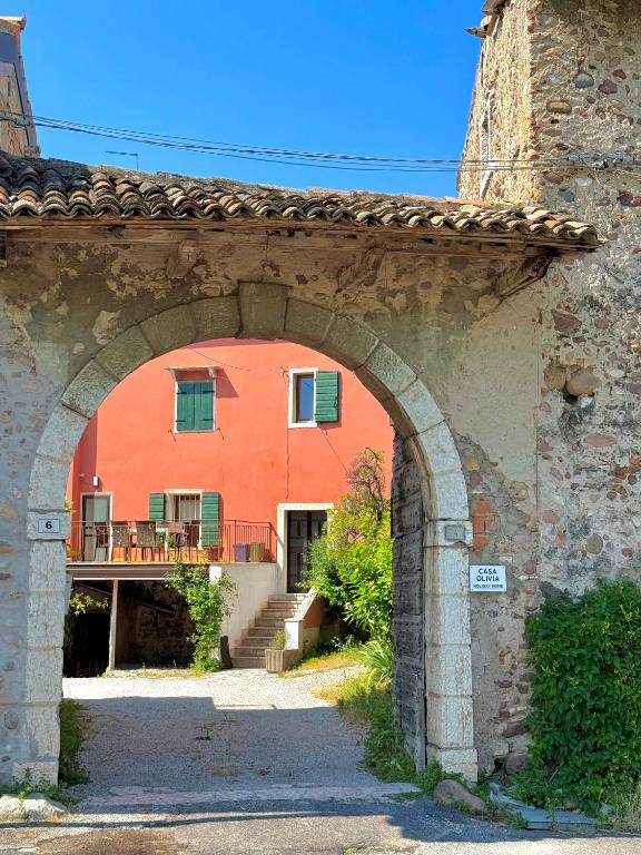 an orange building with an archway in front of it at Casa Olivia Bardolino - Garda Lake in Bardolino