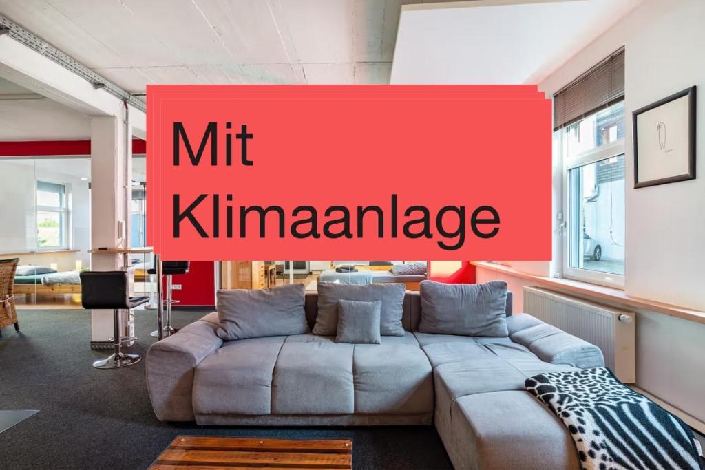 a living room with a couch and a red sign at Loftwohnung 140 qm mit Parkplatz, Wlan, 2 Schlafzimmer, Terrasse , Wäscheservice in Groß-Umstadt
