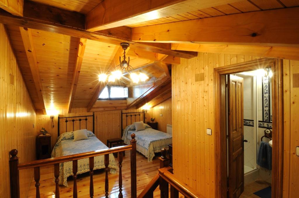 a bedroom with two beds in a wooden cabin at Casa Guela in Pajares