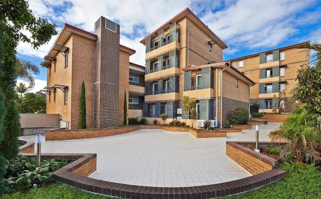 - un bâtiment avec une cour en face dans l'établissement Comfort Inn & Suites Burwood, à Sydney