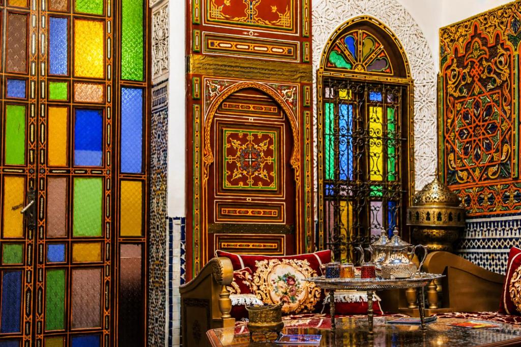 a room with stained glass windows and a couch and a table at Riad Nassim Fez in Fez