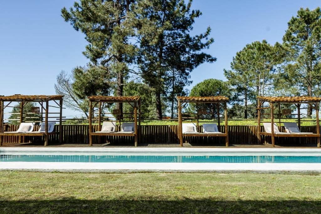 a pool with lounge chairs and a gazebo next to a pool at Ponte Pedra Melides -Nature & Ocean- Adults Only in Melides